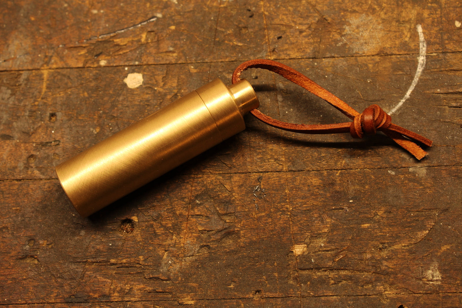 Closed brass match holder on wood work bench