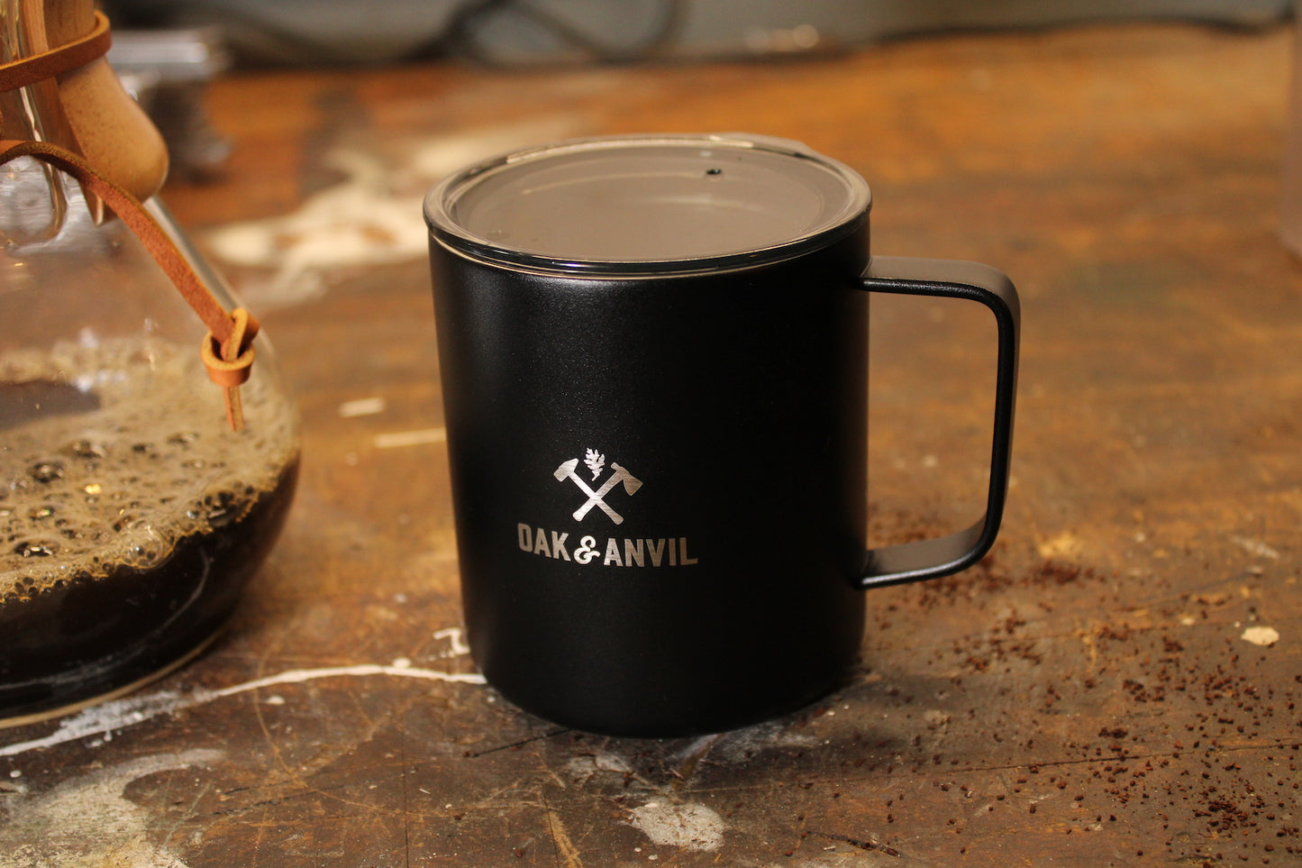 Black stainless steel insulated mug with Oak and Anvil logo on wood