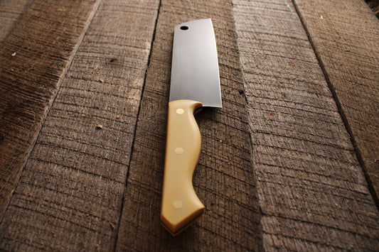 Chef's knife with acid etched blade and antique ivory micarta handle on wood