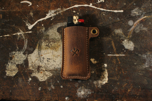 Leather lighter sleeve with Oak and Anvil logo on work bench 