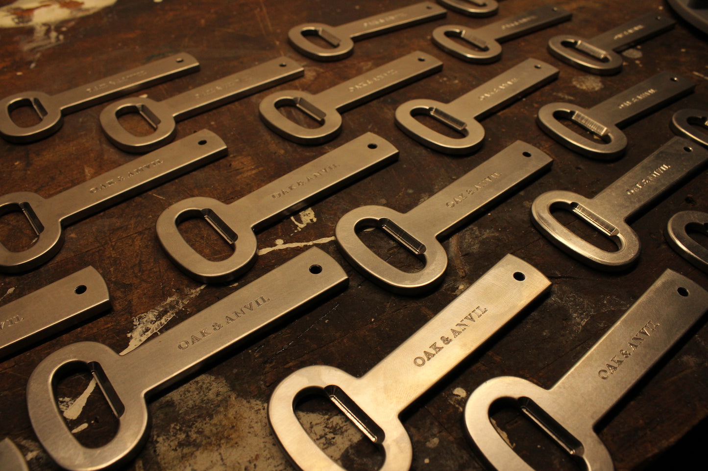 unfinished steel bottle openers on wood bench 